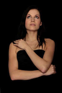 Portrait of a beautiful young woman over black background