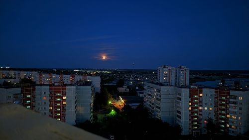 High angle view of illuminated buildings against sky at dusk