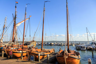 Sailboats moored in harbor