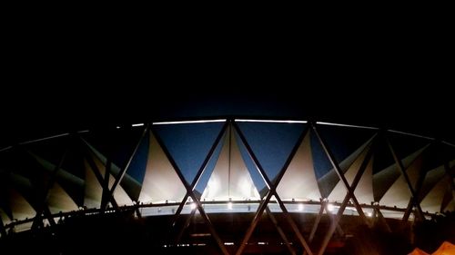 Low angle view of illuminated bridge against clear blue sky at night