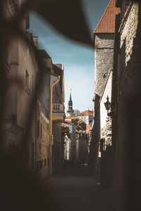 Narrow alley amidst buildings in town against sky