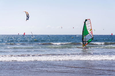 People in sea against sky