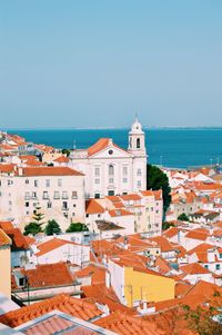 High angle view of townscape by sea against sky