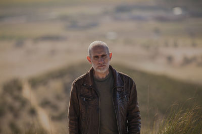 Portrait of adult man standing on field