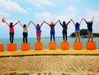 People standing on shore against sky