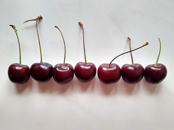 Close-up of cherries on table against white background