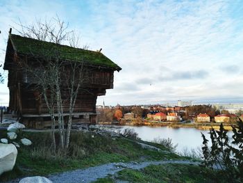 Buildings by river against sky