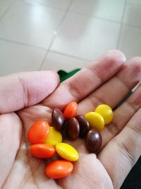 Cropped hand holding multi colored candies