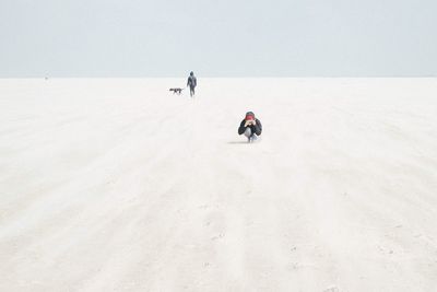 People walking on snow covered landscape