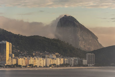 Buildings in city against cloudy sky