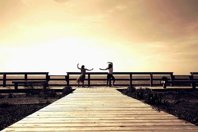 Pier on lake at sunset