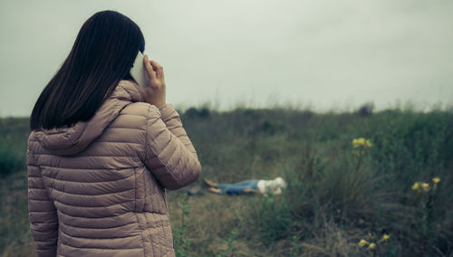 Woman on her back calling emergency services when she find a dead body outdoors