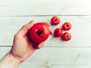 Close-up of hand holding strawberries on table