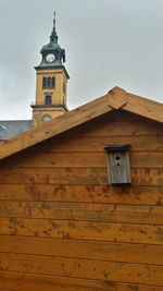 Wooden house against church