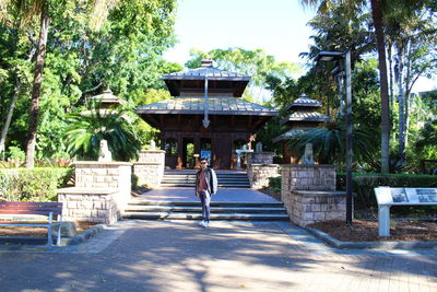 Rear view of woman walking along built structure