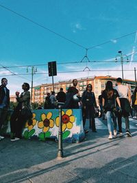 People standing on street against sky in city