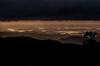 Scenic view of silhouette mountains against sky at sunset