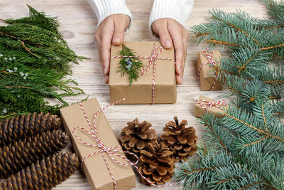 Cropped hands of woman with gift on table