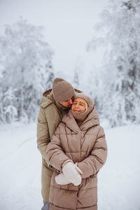 Loving couple hugging in the winter forest