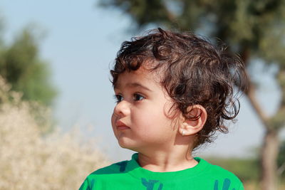 Portrait of cute boy looking away outdoors