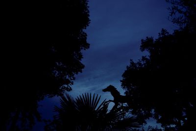 Low angle view of silhouette trees against sky