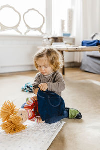 Cute girl playing with stuffed toy at home