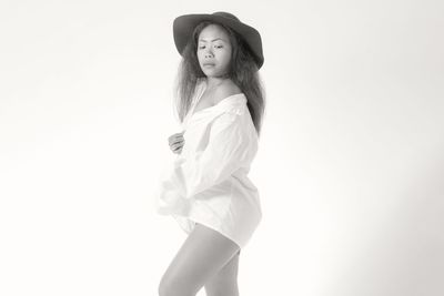 Portrait of woman standing against white background