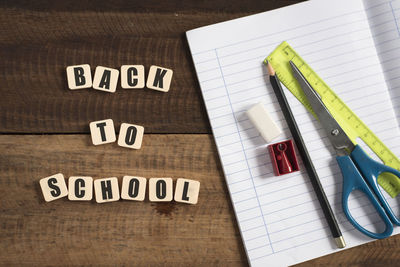 Close-up of text with books and pencils on table