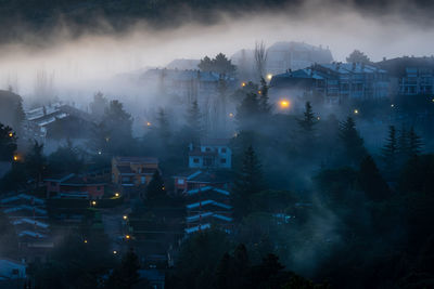 High angle view of illuminated cityscape against sky at night