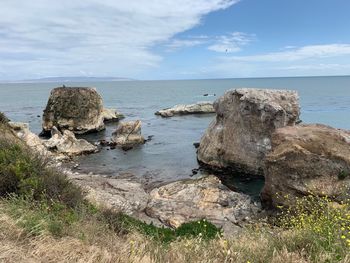 Rocks on sea shore against sky