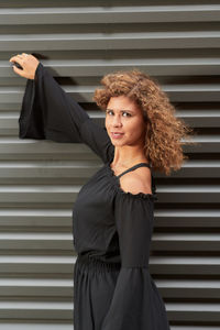 Portrait of woman standing against brick wall