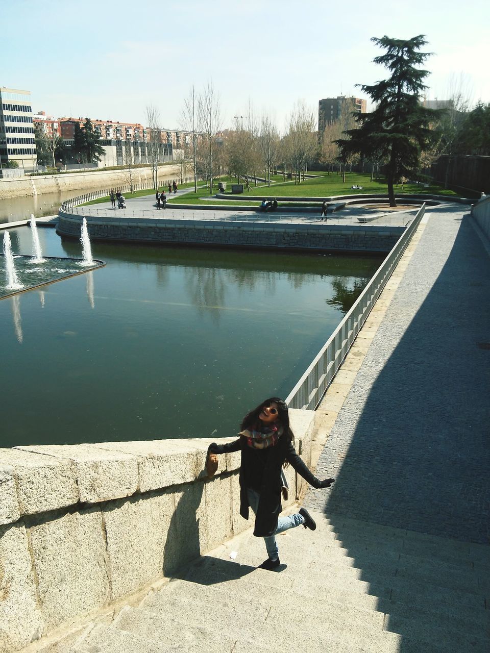 architecture, built structure, building exterior, water, lifestyles, full length, rear view, leisure activity, river, city, sunlight, railing, connection, standing, casual clothing, bridge - man made structure, day, walking