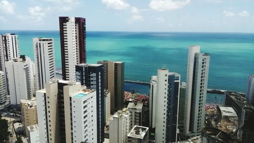 High angle view of cityscape by sea against sky