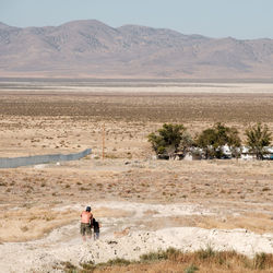 Rear view of people walking on sand dune in desert