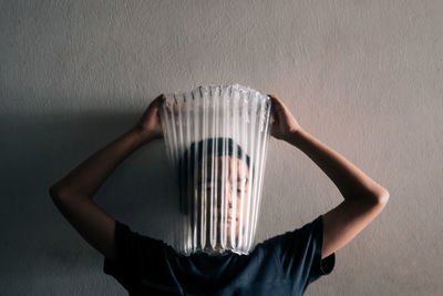 Midsection of man holding ice cream against wall