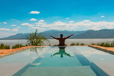 A shirtless man on a infinity swimming pool at lake jipe in tsavo west national park in kenya