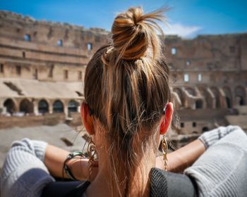 Rear view of woman in front of building