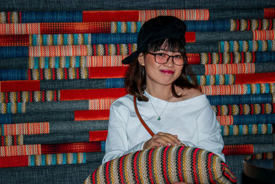 Portrait of young woman smiling while sitting on sofa