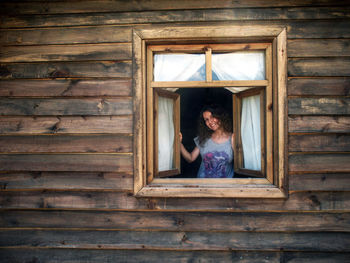 Woman sitting on window of building
