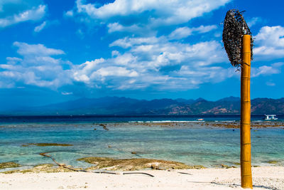 Scenic view of beach against mountains and blue sky