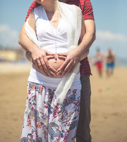Pregnant woman and husband making heart shape sign
