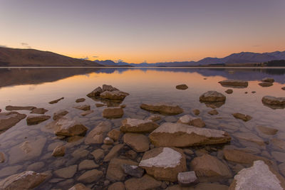 Scenic view of lake against sky at sunset