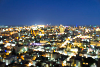 High angle view of illuminated buildings against clear sky at night