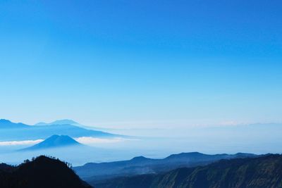 Scenic view of mountains against blue sky