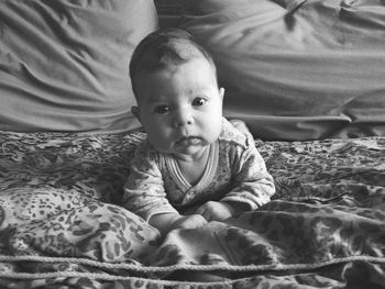 Portrait of cute baby lying on bed