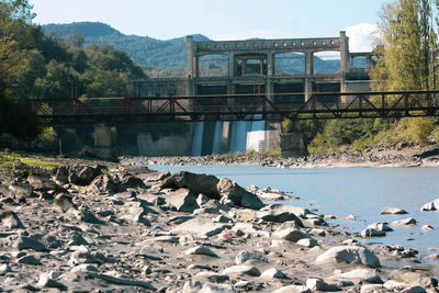 Bridge over river against cloudy sky