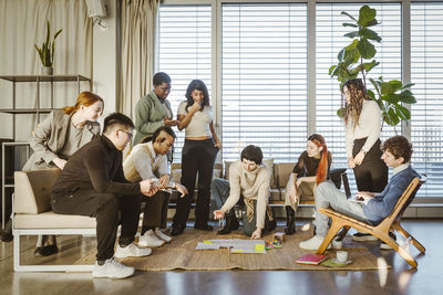 Multiracial male and female entrepreneurs discussing business strategy in meeting at creative office