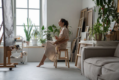 Young woman sitting on sofa at home