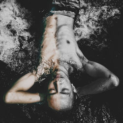 High angle portrait of shirtless man lying water