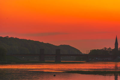 Scenic view of river against romantic sky at sunset